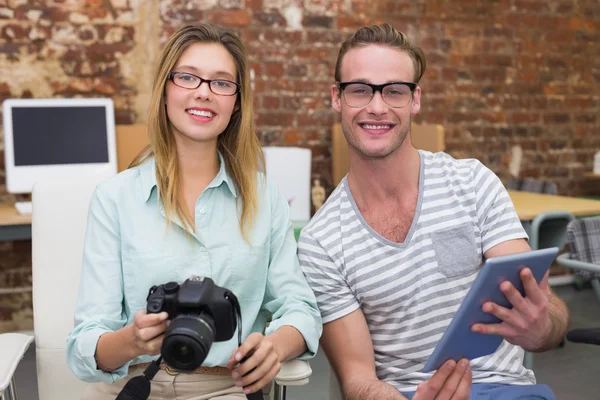 Casual colleagues with digital camera and tablet in office — Stock Photo, Image