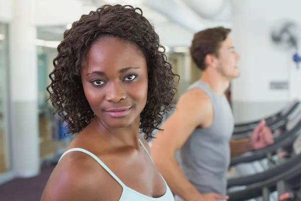 Fit mujer sonriendo a la cámara en la cinta de correr — Foto de Stock