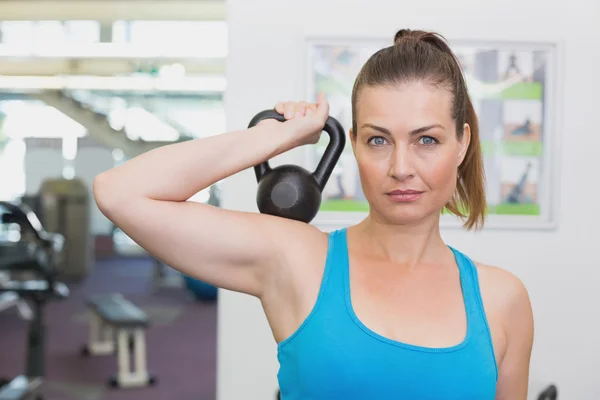 Ajuste morena haciendo ejercicio con kettlebell —  Fotos de Stock