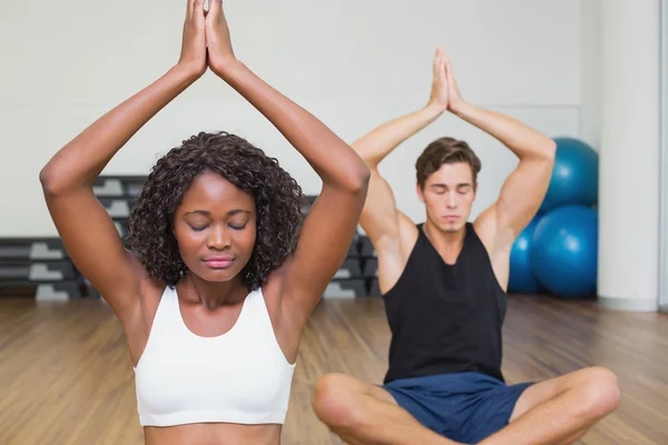Passar paret sitter i lotus pose i fitnesstudio — Stockfoto