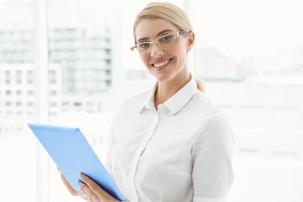Businesswoman with clipboard in office — Stock Photo, Image