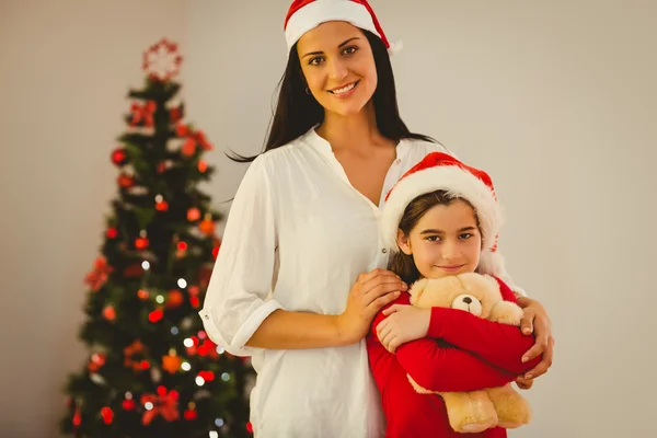 Festive mother and daughter smiling at camera — Stock Photo, Image