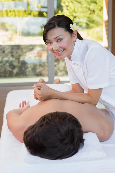 Vrouwelijke masseur masseren mans terug — Stockfoto