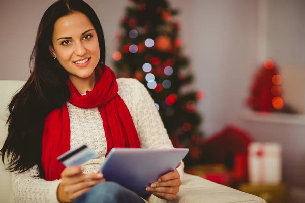 Jolie brune faisant du shopping en ligne avec tablette à Noël — Photo