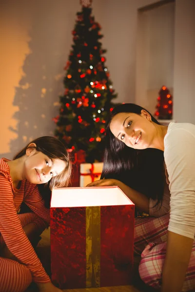 Madre e hija festiva abriendo un brillante regalo de Navidad —  Fotos de Stock