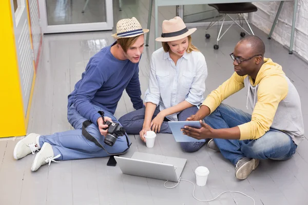 Colleghi casuali che utilizzano tablet digitale sul pavimento — Foto Stock