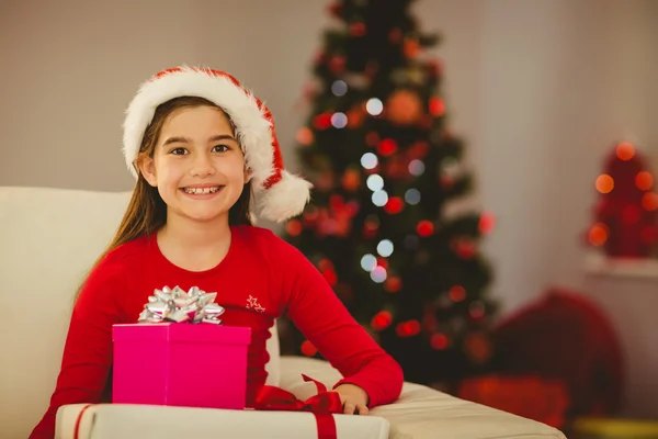 Slavnostní holčička se usmívá na fotoaparát s dárky — Stock fotografie