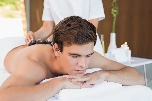 Mann erhält Steinmassage — Stockfoto