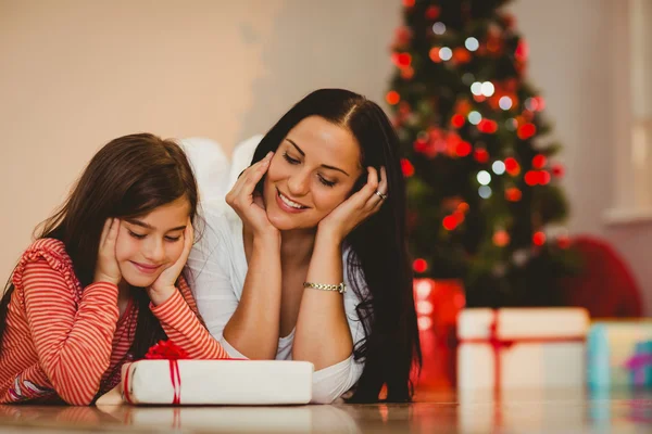 Festive mother and daughter smiling at gift — Stock Photo, Image