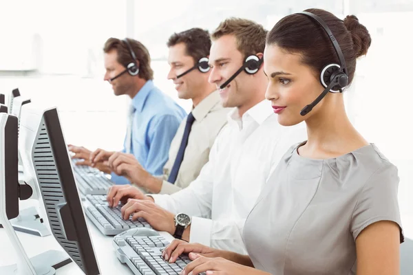 Les gens d'affaires avec des écouteurs utilisant des ordinateurs dans le bureau — Photo