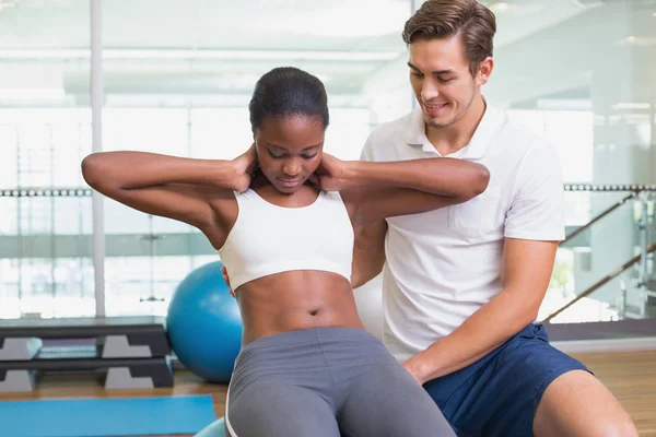 Treinador pessoal trabalhando com o cliente em bola de exercício — Fotografia de Stock