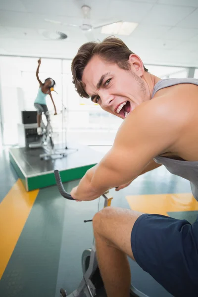 Hombre guapo sonriendo a la cámara en clase de spinning — Foto de Stock