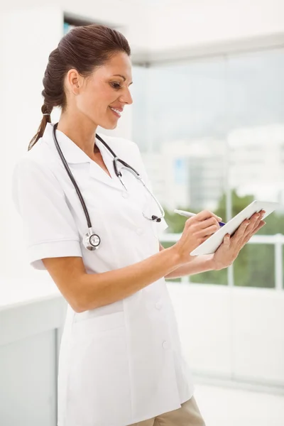 Seção média de médico feminino usando comprimido digital em consultório médico — Fotografia de Stock