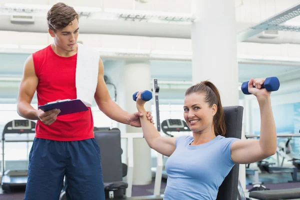 Persoonlijke trainer helpen client lift halters — Stockfoto