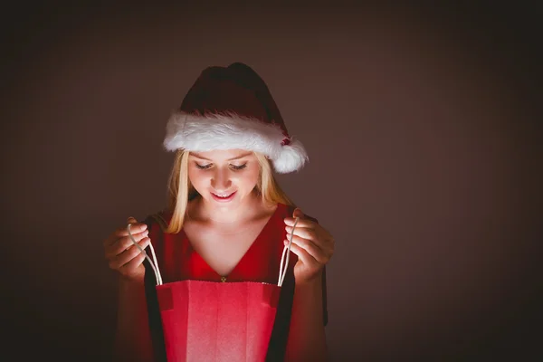 Loira festiva abrindo um saco de presente — Fotografia de Stock