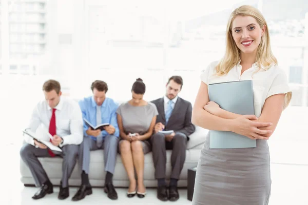 Businesswoman against people waiting for interview — Stock Photo, Image