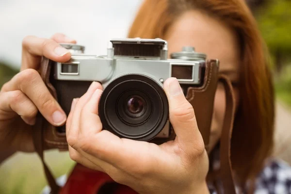 Pretty redhead taking a picture with retro camera — Stock Photo, Image