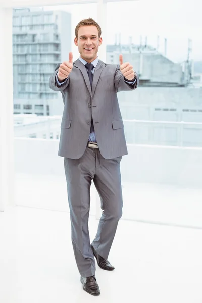 Businessman gesturing thumbs up in office — Stock Photo, Image