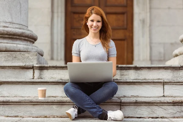 Leende vackra redhead att skriva på laptop — Stockfoto