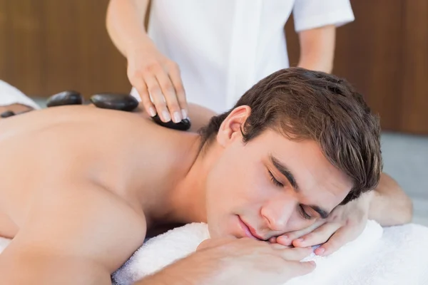 Mann erhält Steinmassage — Stockfoto