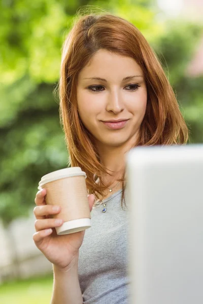 Woman with disposable cup and laptop sitting on bench — Stock Photo, Image