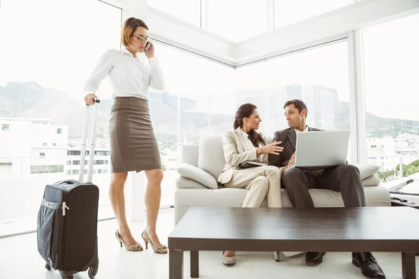 Gente de negocios usando laptop y colega con equipaje — Foto de Stock