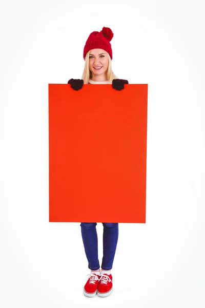Festive blonde showing a red poster — Stock Photo, Image