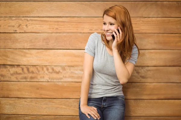 Alegre pelirroja apoyada contra la pared de telefonía — Foto de Stock