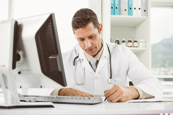 Médico usando computadora en consultorio médico — Foto de Stock