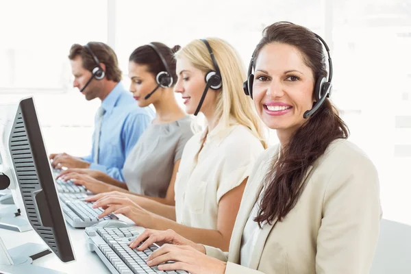 Gente de negocios con auriculares usando computadoras en la oficina —  Fotos de Stock