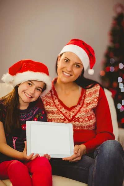 Festive mother and daughter showing tablet screen — Stock Photo, Image