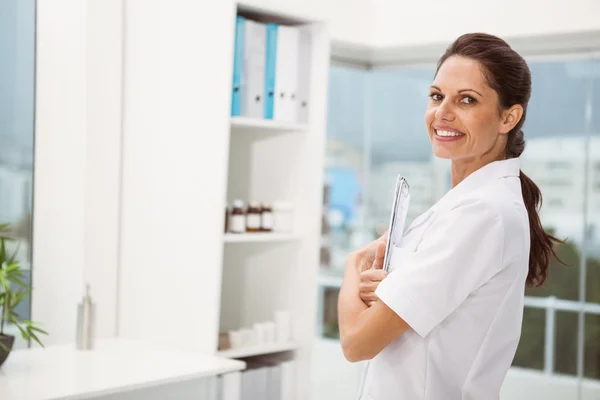 Female doctor holding clipboard in medical office — Stock Photo, Image