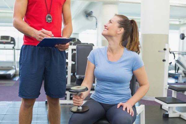 Personal trainer working with client holding dumbbell — Stock Photo, Image