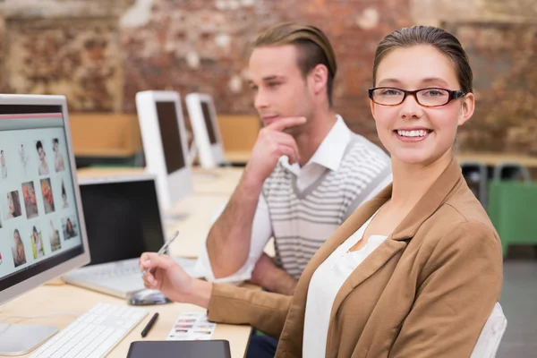 Redattori di foto sorridenti che utilizzano computer in ufficio — Foto Stock