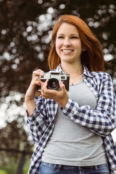 Mulher vestindo jeans e verificar camisa segurando câmera — Fotografia de Stock