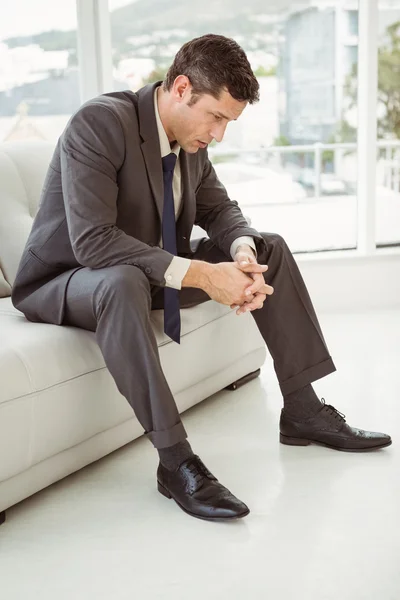 Worried businessman sitting on couch — Stock Photo, Image