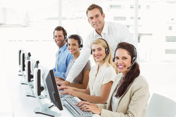 Geschäftsleute mit Headsets benutzen Computer im Büro — Stockfoto
