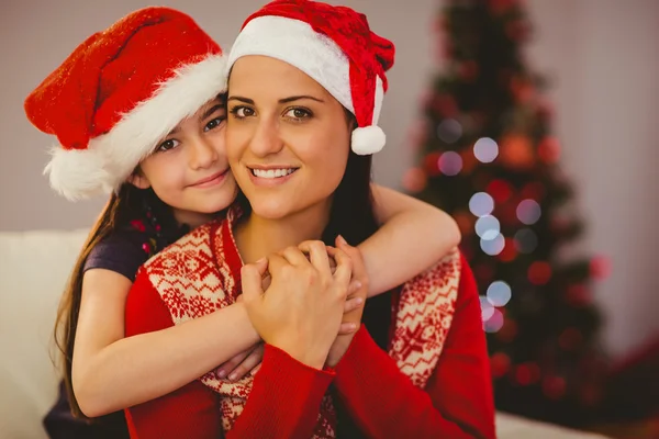 Festive mother and daughter smiling at camera — Stock Photo, Image