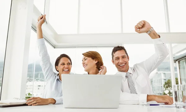 Gente de negocios animando delante de la computadora portátil en la oficina —  Fotos de Stock