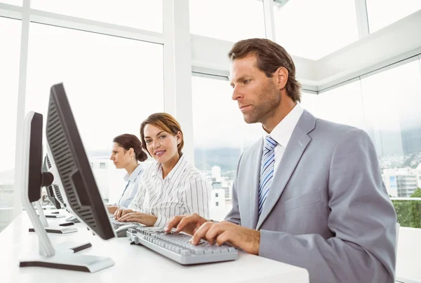 Gente de negocios con auriculares usando computadoras en la oficina —  Fotos de Stock