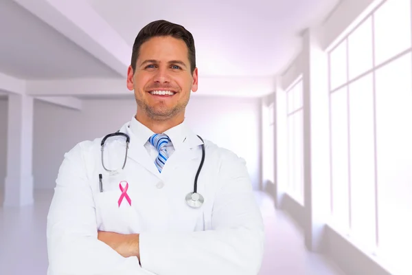 Composite image of handsome doctor with arms crossed — Stock Photo, Image