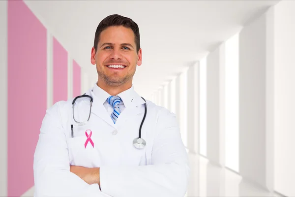 Composite image of handsome doctor with arms crossed — Stock Photo, Image