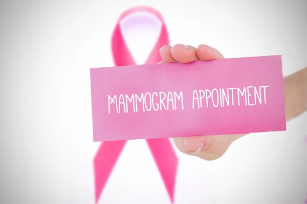 Composite image of young woman holding pink card — Stock Photo, Image