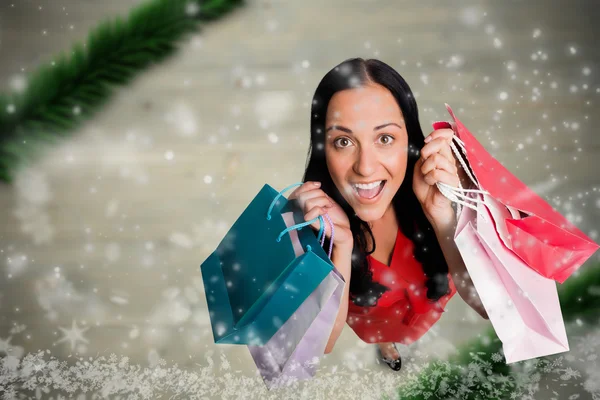 Imagen compuesta de la mujer de pie con bolsas de compras — Foto de Stock