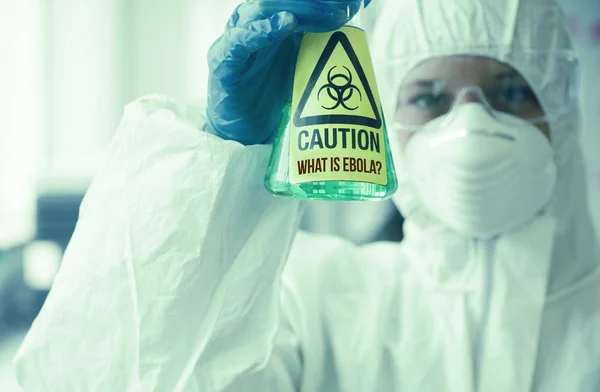 Scientist in protective suit holding beaker — Stock Photo, Image