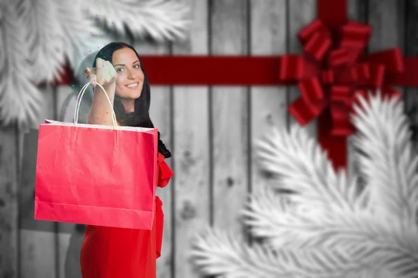 Složený obraz ženy stojící s nákupní taškou — Stock fotografie