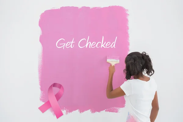 Composite image of young woman painting her wall in pink — Stock Photo, Image