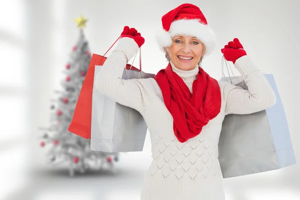 Imagen compuesta de mujer festiva sosteniendo bolsas de compras — Foto de Stock