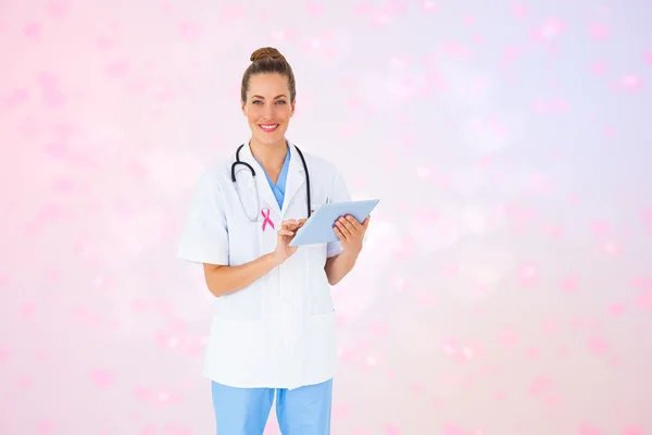 Composite image of pretty nurse using tablet pc — Stock Photo, Image