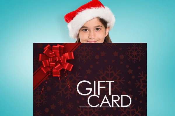 Composite image of festive little girl showing card — Stock Photo, Image